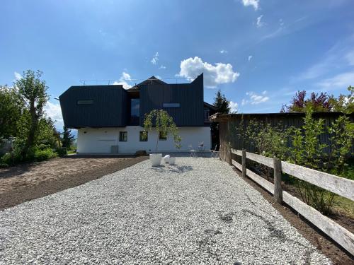 a house with a black roof and a fence at Kaps Wohnen in Saalfelden am Steinernen Meer