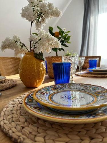 una mesa con un plato y un jarrón con flores en Landhaus mit Pool en Burgthann