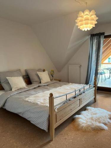a bedroom with a bed and a chandelier at Landhaus mit Pool in Burgthann