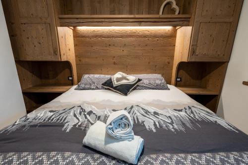 a bed with two towels on top of it at Casa Marzari Lavarone - Appartamento Ginepro in Chiesa