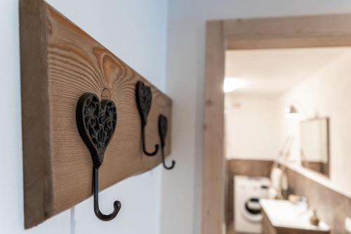 a wooden heart holder on a wall in a bathroom at Casa Marzari Lavarone - Appartamento Ginepro in Chiesa