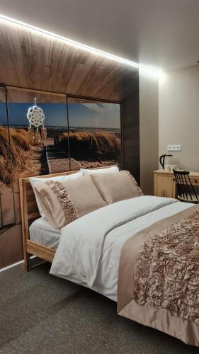 1 dormitorio con 1 cama grande y una foto de playa en A&F studija, en Budraičiai