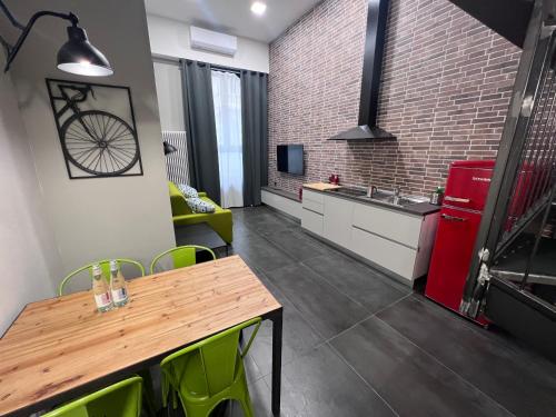 a kitchen with a wooden table and green chairs at Residence Star in Turin