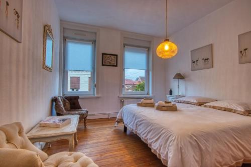 a bedroom with two beds and a table and two chairs at La colombe 43 in Steenvoorde