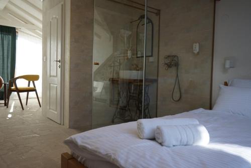 a bedroom with a shower and a bed with towels at Hotel Restoran Humsko in Trebinje