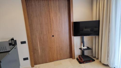 eine Holztür mit einem TV in einem Zimmer in der Unterkunft Bright Casablanca Apt in Casablanca