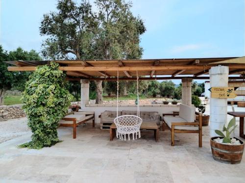 a pavilion with tables and chairs and a swing at Masseria Piccole Taverne in Ostuni
