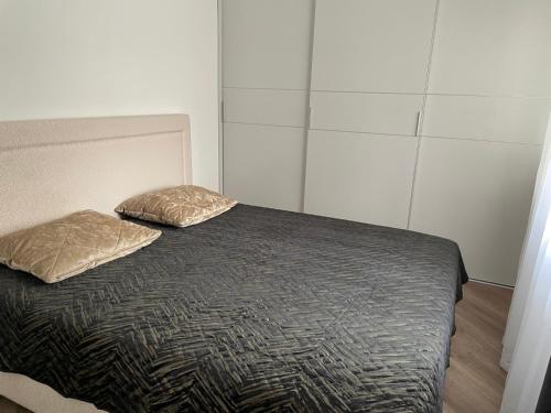 a bed with two pillows on it in a room at Oškinio Apartamentai in Palanga