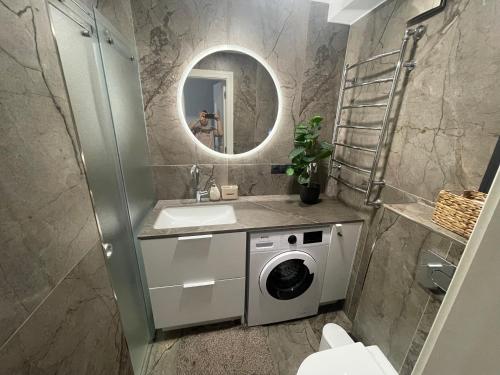 a bathroom with a washing machine and a sink at Oškinio Apartamentai in Palanga