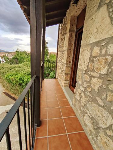 a balcony of a house with a stone wall at Apartamento Puerta del Sol de 1 habitación in Candelario