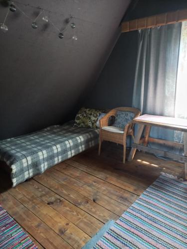 a room with a bed and a table and a chair at Namiņš in Vecumnieki