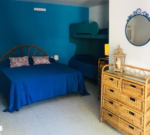 ein blaues Schlafzimmer mit einem Bett und einem Spiegel in der Unterkunft Villaggio Residence Chalet degli Ulivi in Marina di Camerota