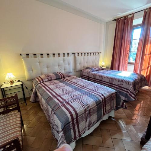 a bedroom with two beds and a window at B&B Podere Cottimellino - Montalcino - Val d'Orcia in Montalcino