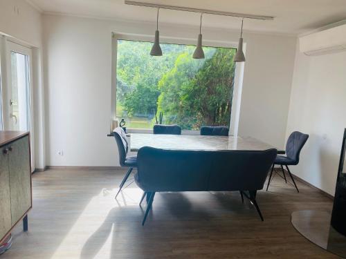 ein Esszimmer mit einem Tisch und Stühlen sowie einem großen Fenster in der Unterkunft Lend city house in Graz