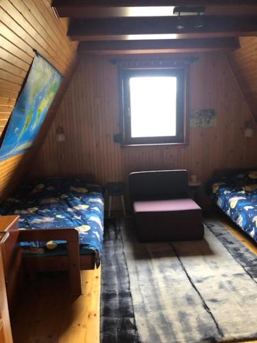 um pequeno quarto com 2 camas e uma janela em Dom na Kaszubach Sulęczyno z widokiem na jezioro em Suleczyno