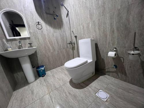 ein Badezimmer mit weißer Toilette und Waschbecken in der Unterkunft Kada Suites in Riad