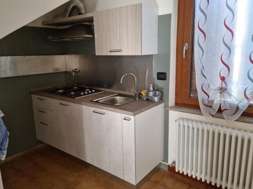 a small kitchen with white cabinets and a sink at DA ARTU' in Udine