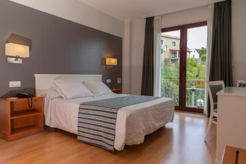 ポブラ・ド・カラミニャルにあるHotel Lombiñaのベッドルーム1室(ベッド1台、大きな窓付)