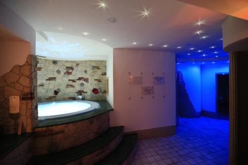 bagno con vasca in una camera con luci blu di Hotel Laurin a Canazei