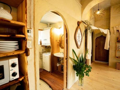 een keuken met een gewelfde deur naar een kamer met een wastafel bij Kafuya miyagi in Ikemi