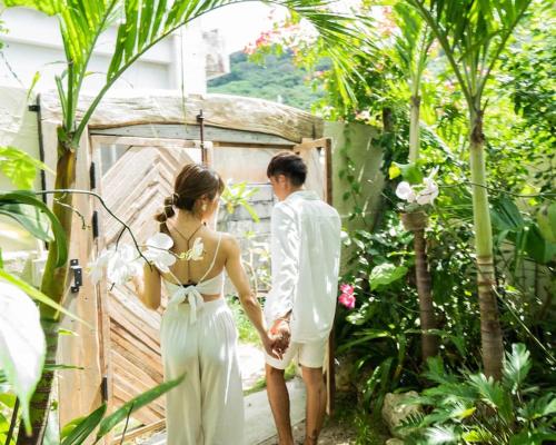 a bride and groom standing in front of a gate at Kafuya miyagi in Ikemi
