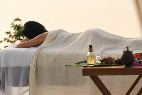 a woman laying on a bed with her head on a table at Kafuya miyagi in Ikemi