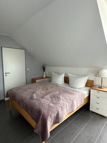 a bedroom with a bed and a dresser with a lamp at Appartement 1 in Bersenbrück