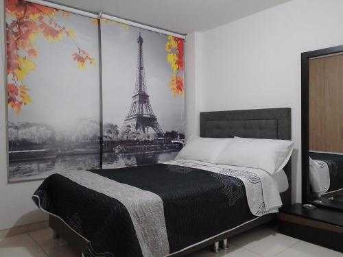 1 dormitorio con 1 cama con una foto de la torre Eiffel en Linda habitación amplia iluminada Bogota Calle 80, en Bogotá