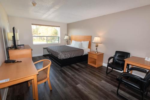 a hotel room with a bed and a desk and chair at Borden Inn and Suites in Angus