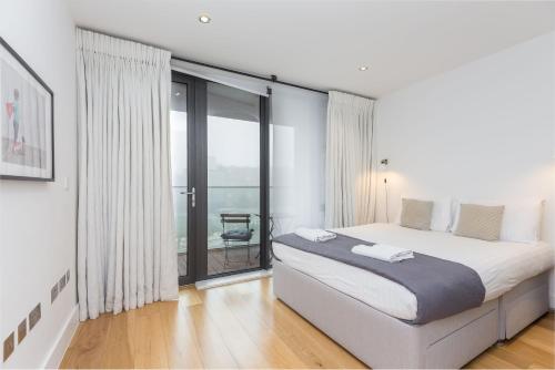 a bedroom with a large bed and a large window at Portobello Apt with Floor-to-Ceiling Views in London