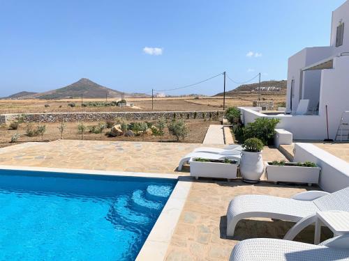 a swimming pool with chairs and a house at Quiet 2-bedroom sea view villa with shared pool in Mármara