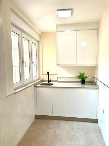 a kitchen with white cabinets and a sink at EL NORTE in Viveiro