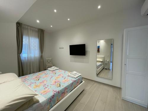 een witte slaapkamer met een bed en een spiegel bij B&B San Luca in Bologna
