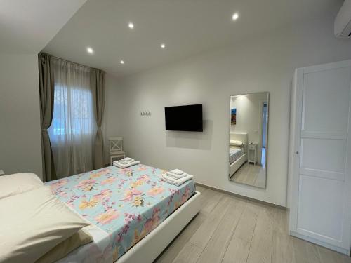 una camera da letto bianca con un letto e uno specchio di B&B San Luca a Bologna