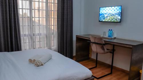 a hotel room with a bed and a desk and a television at MATUNDA CITY MALL & RESORT in Hoeys Bridge