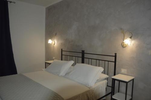 a bedroom with a bed with white sheets and two tables at Depan Dance in Gallipoli