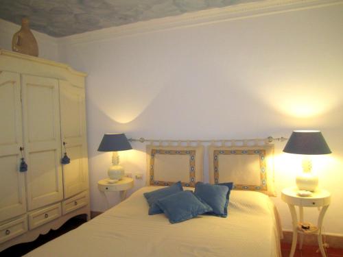 una camera da letto con un letto con cuscini blu e 2 lampade di Villa Carola at Punta Ala (Sea & Golf Club View) a Punta Ala