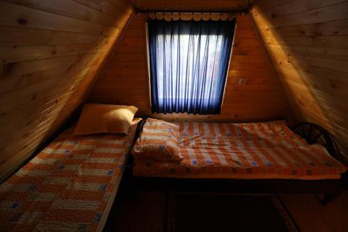 a bedroom with a bed and a window in a cabin at Planinska kuća Bubi - Tara, Zaovine. in Jezdići