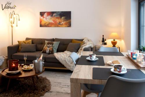 a living room with a couch and a table at Het Veldhuis in As
