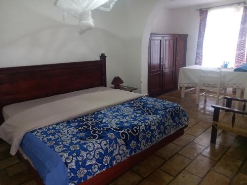 ein Schlafzimmer mit einem Bett mit einer blauen und weißen Decke in der Unterkunft Rwanda African Art Museum in Nyabisindu