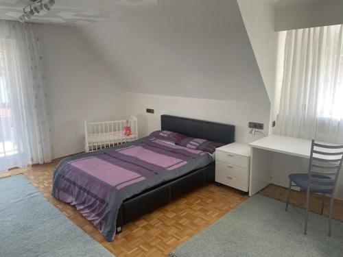 1 dormitorio con cama, escritorio y mesa en Naturpark Ferienwohnung mit Wintergarten en Spraitbach