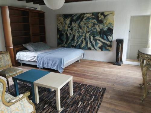 a bedroom with a bed and a painting on the wall at Jolie maison en pierre proche centre-ville in Cherbourg en Cotentin