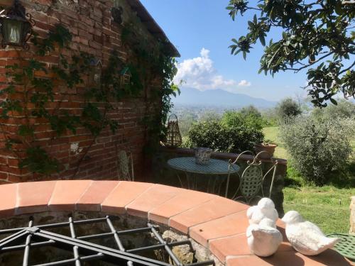 a brick building with a patio with a table at Bed&Breakfast La Madonnina in Marlia