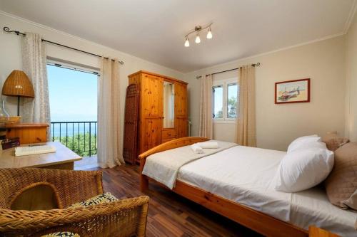 a bedroom with a bed and a desk and a window at Traditional Seaview Home Candili in Corfu Town