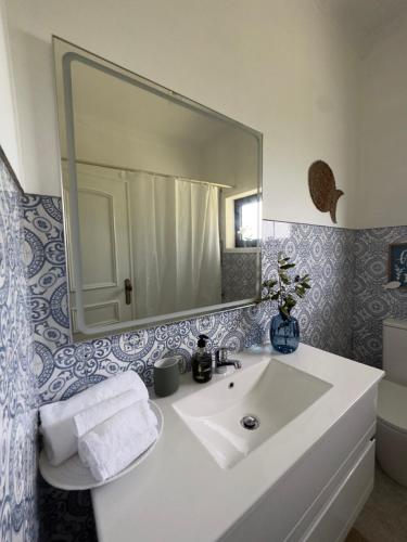 a bathroom with a white sink and a mirror at Casa de Greire in Castelo de Paiva