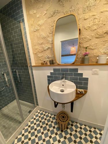 une salle de bain avec un lavabo et un miroir dans l'établissement Le Sarment, à Grézillac
