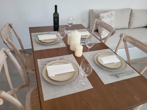 a dining room table with plates and wine glasses at Stavros Residence in Mármara