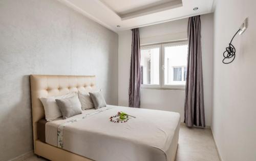 Un dormitorio con una gran cama blanca con flores. en Appartement 3 CHAMBRES ensoleillé à 5 min de la plage El Jadida, en El Jadida