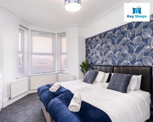 a bedroom with two beds with blue and white pillows at Four Bedroom Large Contractor House By Keysleeps Short Lets Derby in Derby