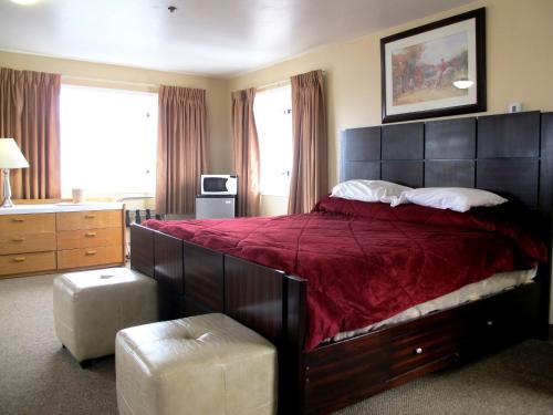 een slaapkamer met een groot bed met een rode sprei bij Merrill Field Inn in Anchorage